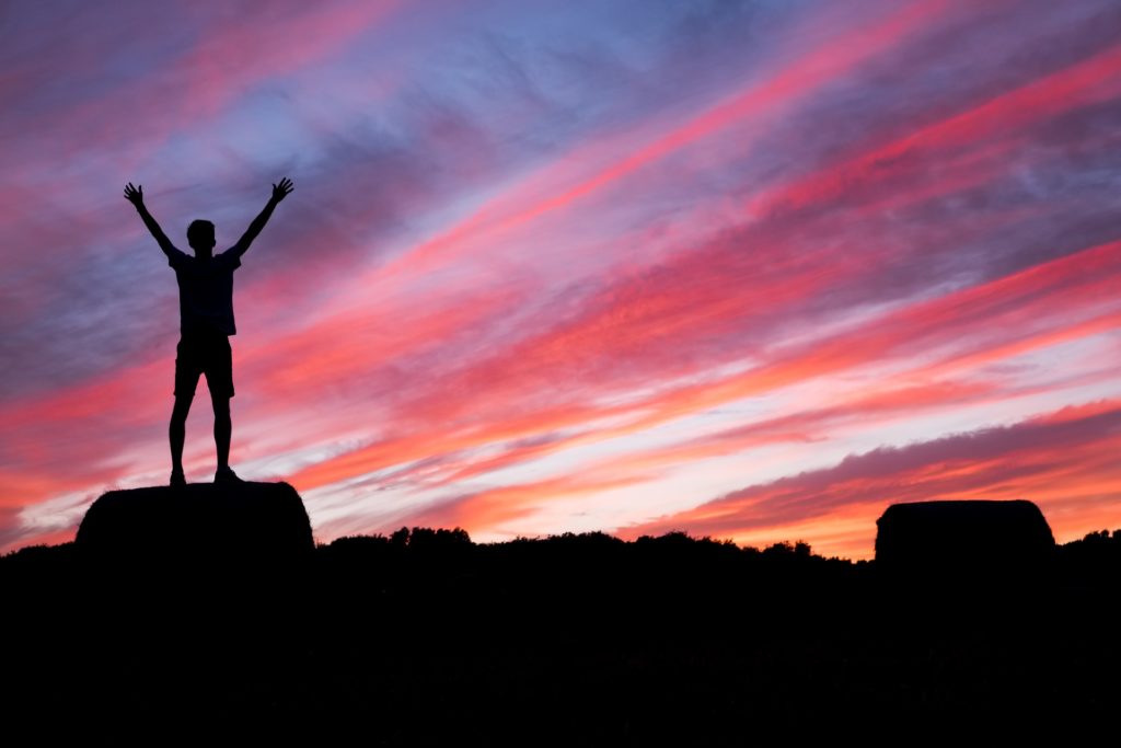 Person's silhouette in front of a pink sunset.