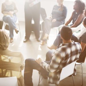 Group of people sitting in a circle talking.