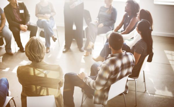 Group of people sitting in a circle talking.